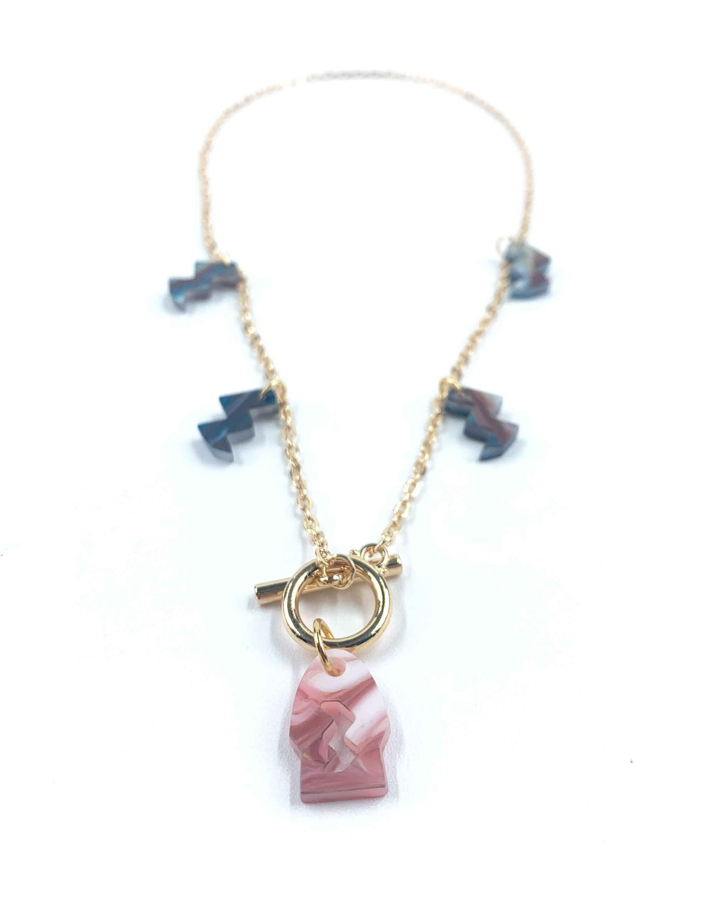 Collar dorado con colgante de resina rosa marmolada y charms geométricos