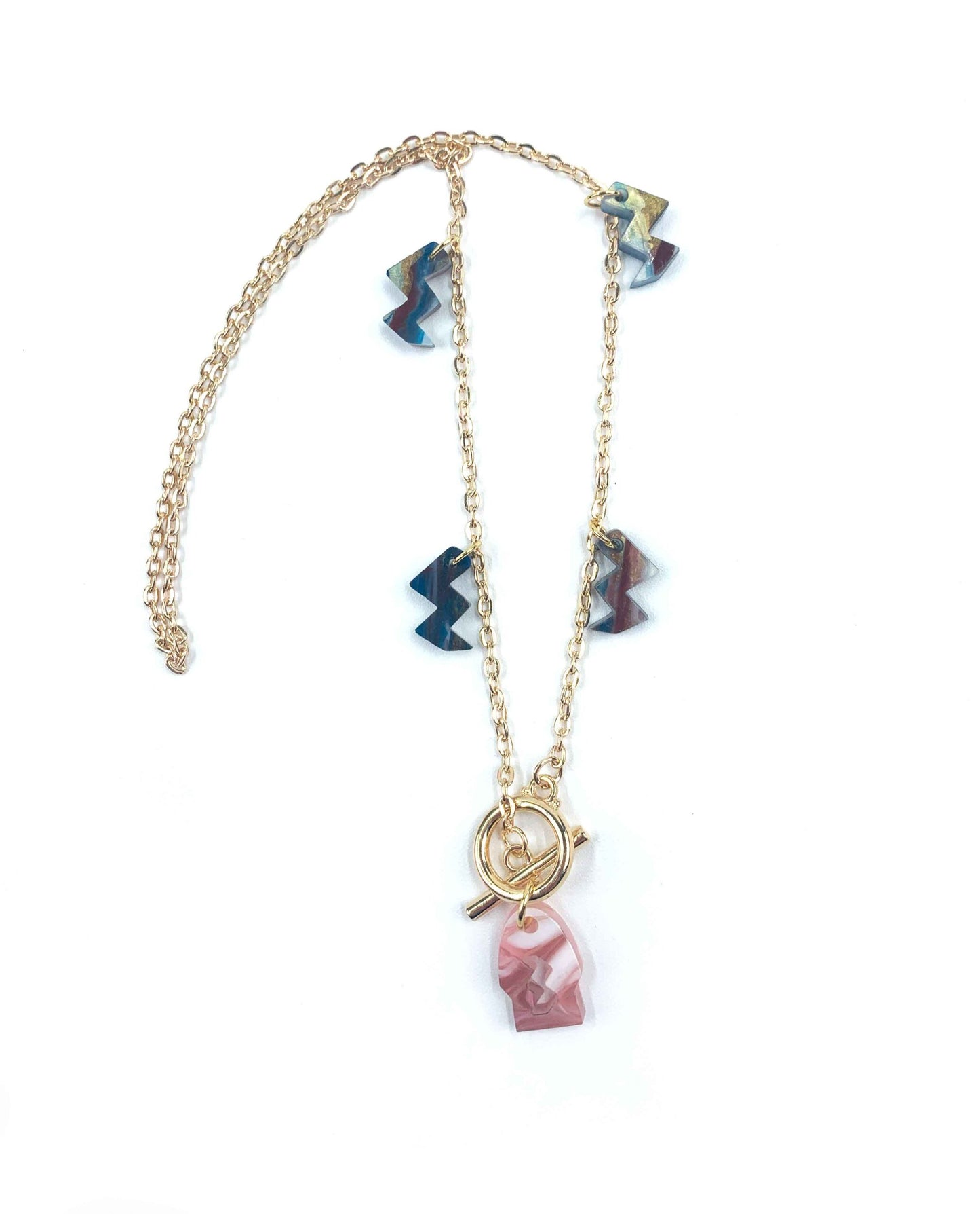 Collar dorado con colgante de resina rosa marmolada y charms geométricos